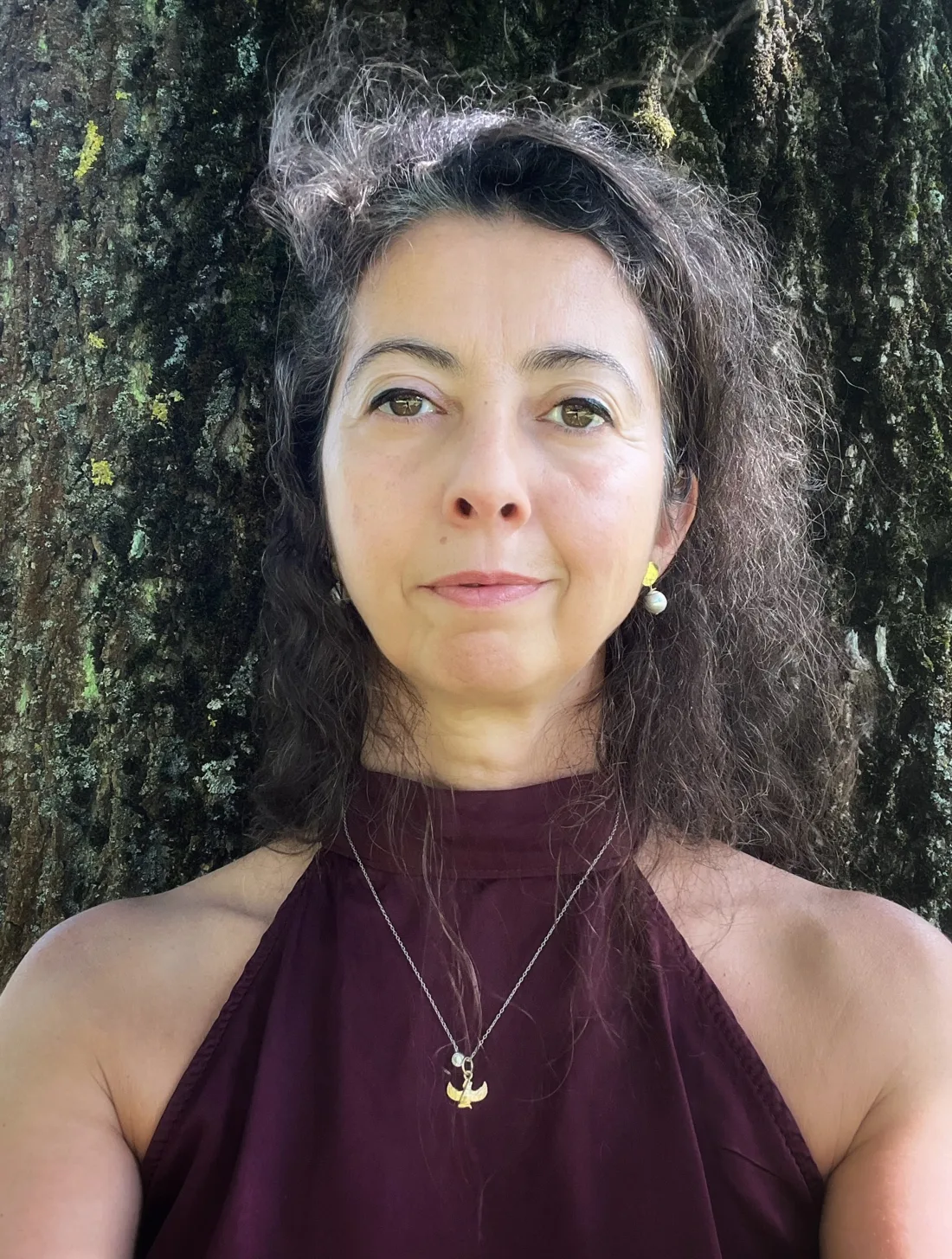 Verónica de Diego Coppen standing against a tree trunk